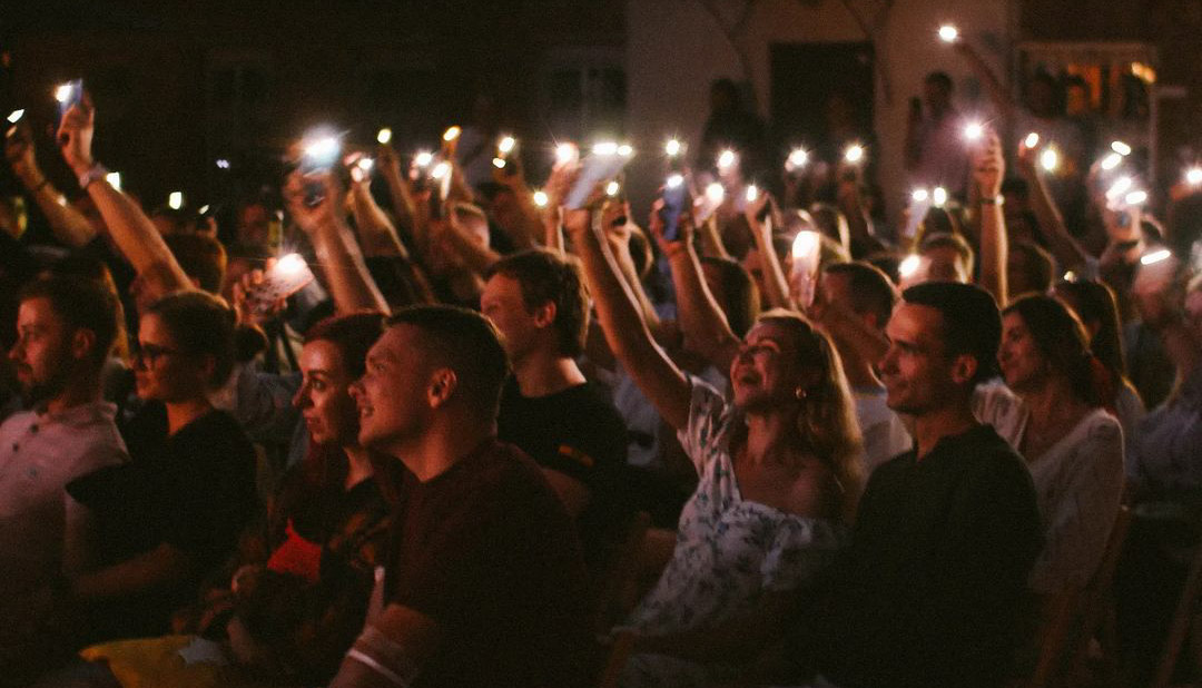 A crowd of people holding candles overhead